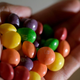 Hand holding pile of Original Skittles in open palm